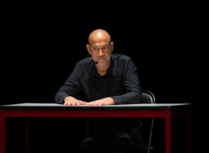 Thierry Roudil sur la scène d'un théâtre lors de son spectacle